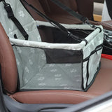 Gray paw print pet car booster seat with mesh sides and safety straps installed on car seat