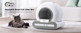 White upgraded smart cat litter box with gray base beside long haired tabby cat on rug