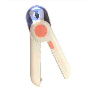 pettechhair dog nail trimmer with LED light and safety guard shown near a dog paw